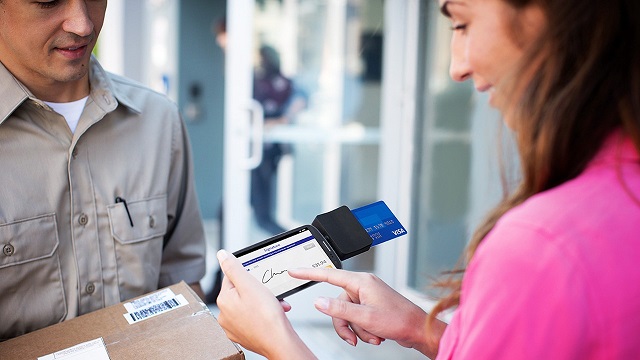 mpos-crosslink-640x360 Woman signing for package using Square Reader on smart phone with her Visa card for payment.