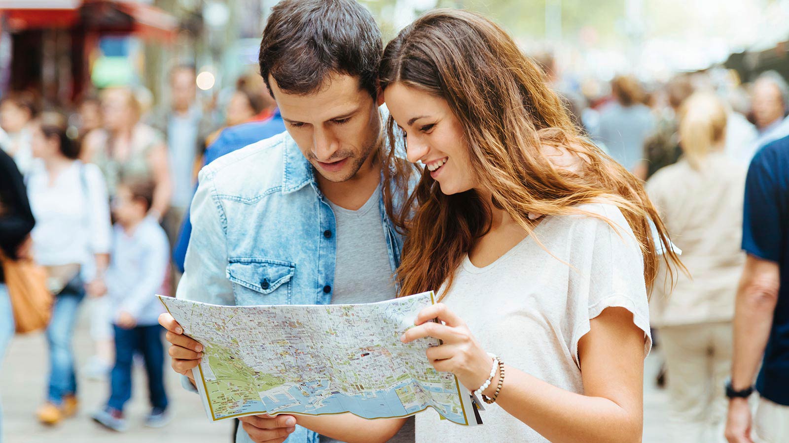 Couple looking at a map for directions in a busy street