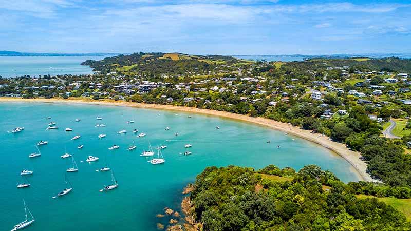 Aerial view on beautiful bay at sunny day with sandy beach and residential suburbs on the background.